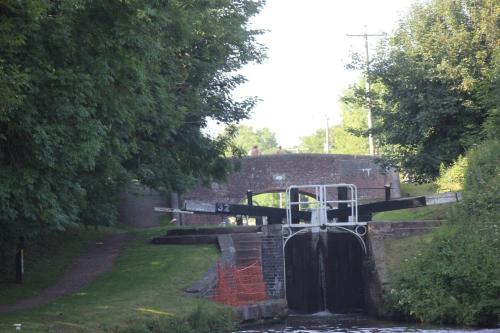 a lock in a canal with water coming out of it at Canalside Beautiful Stone Townhouse in Stone