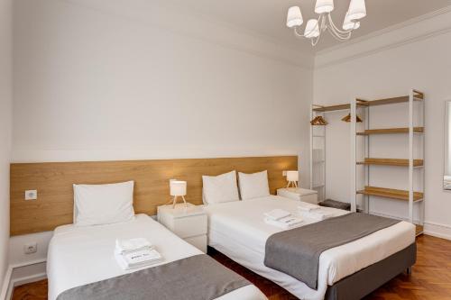 a bedroom with two beds and a chandelier at Home Out Rooms & Apartments in Lisbon