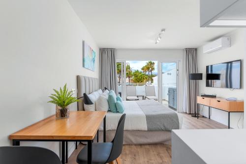 a bedroom with a bed and a desk and a table at Wyndham Residences Golf del Sur in San Miguel de Abona