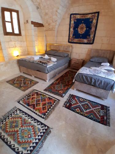 a room with four beds and rugs on the floor at Sular konağı butik otel in Sanlıurfa