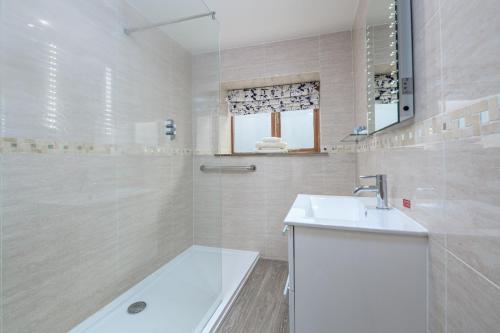 ein weißes Badezimmer mit Waschbecken und Badewanne in der Unterkunft Ash Cottage in Boston