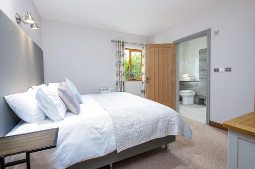 une chambre blanche avec un lit et une salle de bain dans l'établissement Oak Cottage, à Boston