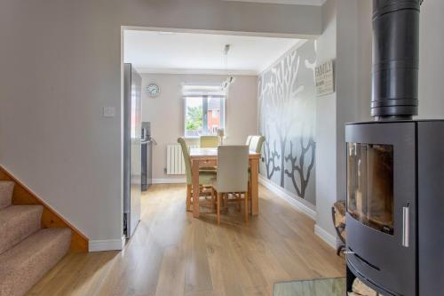 a kitchen and dining room with a table and a fireplace at Canalside Beautiful Stone Townhouse in Stone