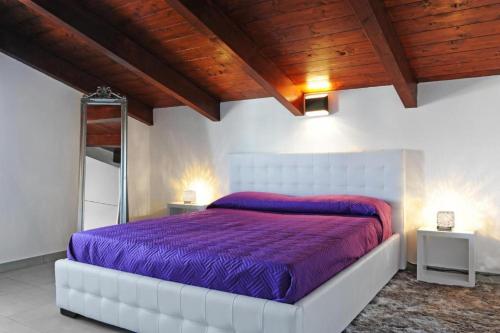 a bedroom with a bed with a purple comforter at Europa in Alghero