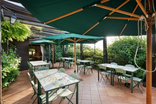 a group of tables and chairs with umbrellas on a patio at Agriturismo Barone Antonio Negri in Fisciano