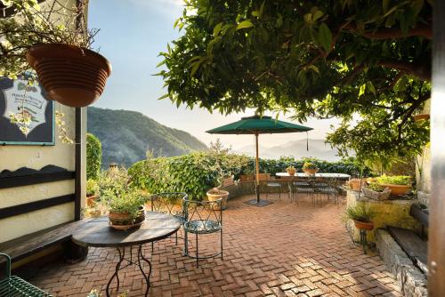 a patio with tables and chairs and an umbrella at Agriturismo Barone Antonio Negri in Fisciano