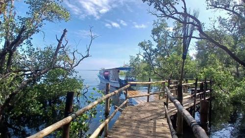a dock on the water with a boat on it at Lekker Gezellig Dive Resort Manado in Bunaken
