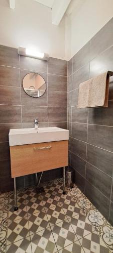 une salle de bain avec un lavabo et un miroir dans l'établissement Le Mas des Fontettes, gite 14 personnes, piscine chauffée, propriété 5ha, barbecue, à Sahune