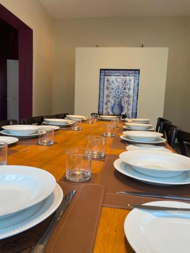 a long table with white plates and glasses on it at Estalagem Portucale in Águas de Lindóia