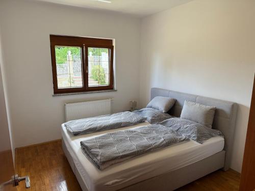 a bed in a white room with a window at Villa Kopic in Opatija
