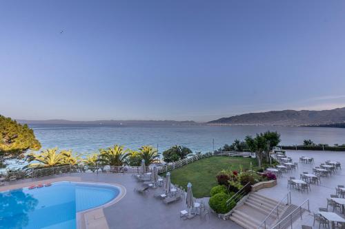 a resort with a pool and a view of the water at Messinian Bay in Kalamata