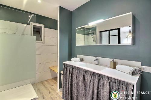 une salle de bain avec un lavabo et un miroir dans l'établissement L'embellie, à Quimper