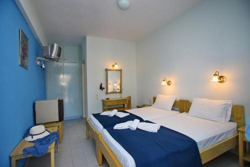 a bedroom with a large bed and a television at Dolphin Hotel in Skopelos Town