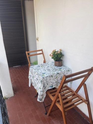 a table and chairs on a patio with a potted plant at Casa Bel Tempo in Pieve di Teco