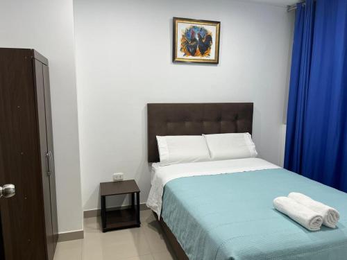 a bedroom with a bed with blue sheets and a blue curtain at MH Apartments Ica 3 in Ica