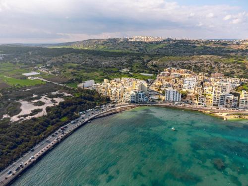 an aerial view of a city and the ocean at Xemxija Bay Hotel in St Paul's Bay