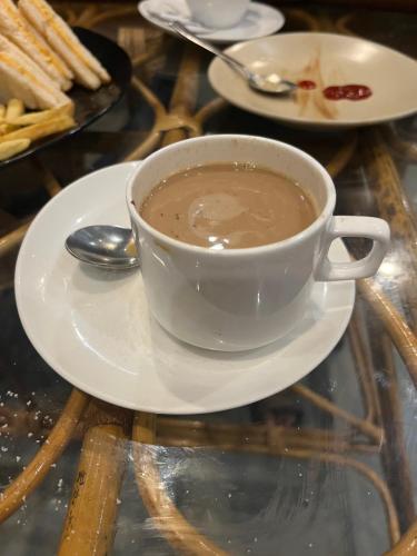 uma xícara de café em um prato sobre uma mesa em Pocketchange stays em Rishikesh