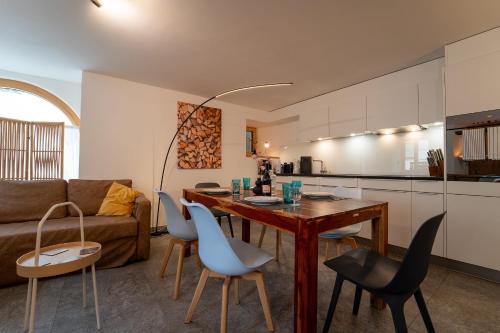 a kitchen and living room with a table and chairs at Moderne helle Ferienwohnung 1-6 Pers - Chasa32 in Guarda in Guarda