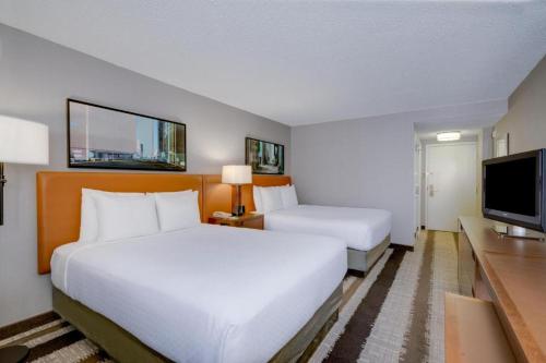 a hotel room with two beds and a flat screen tv at Crowne Plaza Dulles Airport by IHG in Herndon