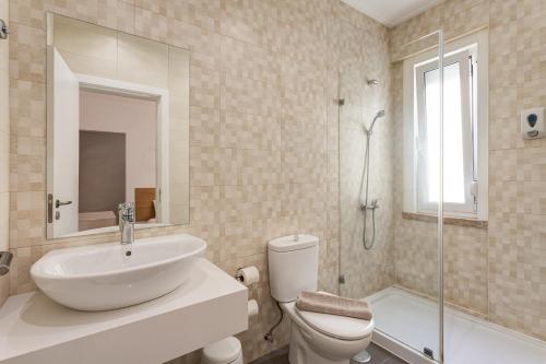 a bathroom with a sink and a toilet and a shower at Home Out Rooms & Apartments in Lisbon