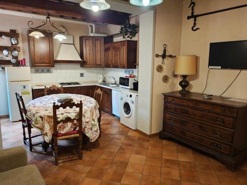 a kitchen with a table and a kitchen with a microwave at Villa Torricelli Scarperia - Il Giardinetto Residence in Scarperia