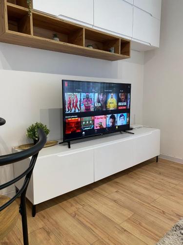 a flat screen tv sitting on a white entertainment center at Urban Oasis Apartment in Sajmište