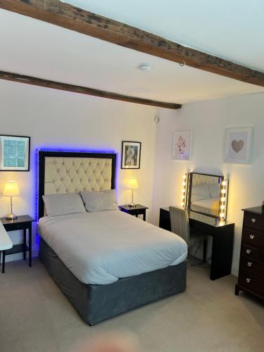a bedroom with a bed and two tables and a desk at The Retreat Averham in Kelham