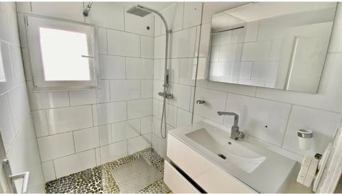 une salle de bain blanche avec un lavabo et un miroir dans l'établissement Sewa surf House 10min de Capbreton, à Bénesse-Maremne
