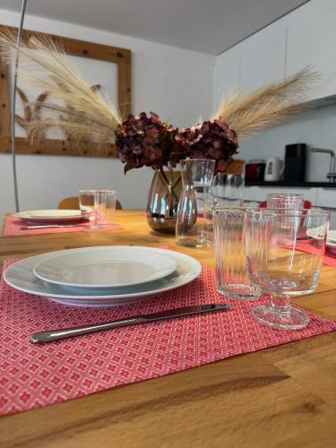 a table with a plate and glasses on a red placemat at Moderne helle Ferienwohnung 1-6 Pers - Chasa32 in Guarda in Guarda