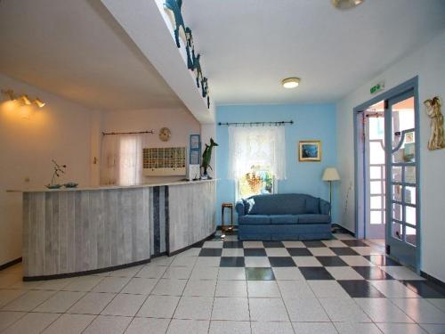 a living room with a kitchen and a blue couch at Dolphin Hotel in Skopelos Town