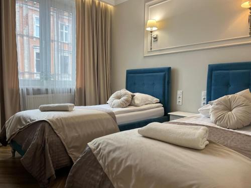 pokój hotelowy z dwoma łóżkami i oknem w obiekcie Family & Business Sauna Apartments Plac Wolności CENTRUM Downtow, - Piękny Apartament - 5 Bedroom with Private Sauna, Bath with Hydromassage, Parking, Catering Options w Kielcach