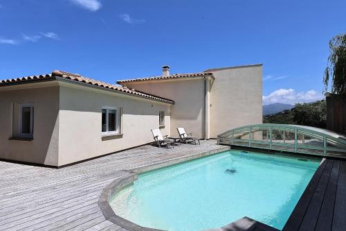 une maison avec une grande piscine sur une terrasse en bois dans l'établissement Superbe villa entre mer et montagne avec piscine, à Viggianello