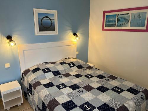 une chambre avec un lit à carreaux noirs et blancs dans l'établissement T2 Cosy, Piscine, Parking et Résidence front mer, à Les Sables-dʼOlonne