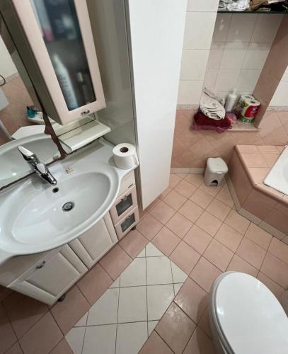 a bathroom with a sink and a toilet and a tv at La Casetta in Tuglie