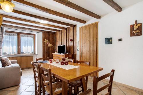 a dining room with a wooden table and chairs at La Vieille Cloche in Saint-Rhémy-en-bosses