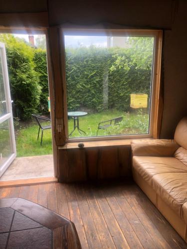 a living room with a couch and a window at Sweet Honey homestay in Jūrmala