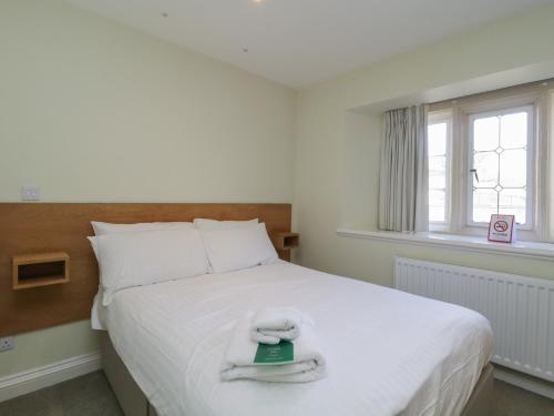 a bedroom with a white bed with a book on it at Harcombe House Rooms - First Floor Double in Newton Abbot