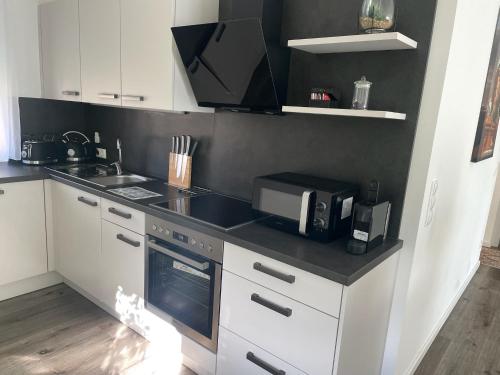 a kitchen with a counter top with a microwave and a sink at Sorinas Home WB16 Top 11 in Wagersbach