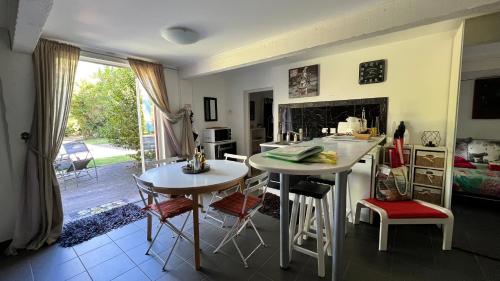 - une cuisine et un salon avec deux tables et des chaises dans l'établissement La Grange au beau milieu des Pins, à Lacanau