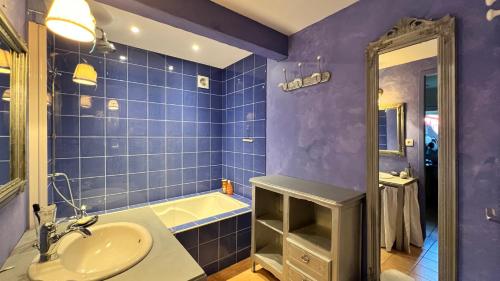 a blue bathroom with a sink and a tub at La Grange au beau milieu des Pins in Lacanau