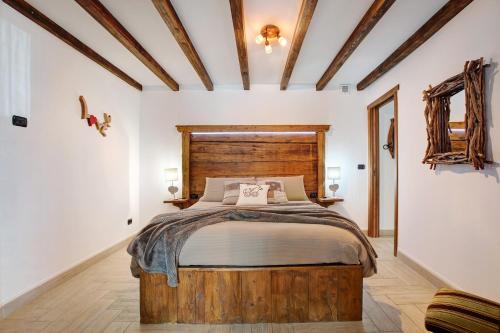a bedroom with a bed with a wooden headboard at La Vieille Cloche in Saint-Rhémy-en-bosses