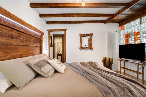 a bedroom with a large bed and a flat screen tv at La Vieille Cloche in Saint-Rhémy-en-bosses