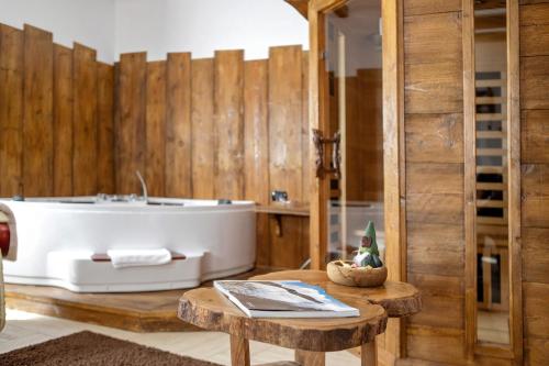 a bathroom with a bath tub and a table at La Vieille Cloche in Saint-Rhémy-en-bosses
