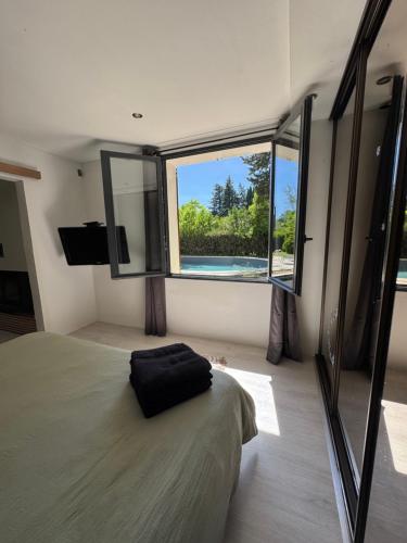 une chambre avec un lit et une grande fenêtre dans l'établissement La maison vauclusienne, à Carpentras