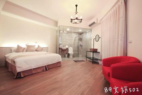 a bedroom with a bed and a red chair at A Homestay of the Yiwen Brigade in Magong
