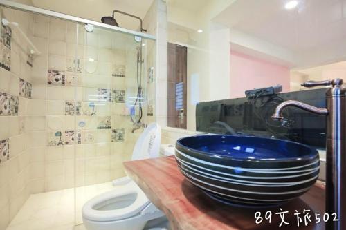a bathroom with a blue sink and a toilet at A Homestay of the Yiwen Brigade in Magong