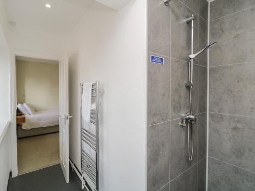 a bathroom with a walk in shower next to a bedroom at Harcombe House Rooms - First Floor Single in Newton Abbot