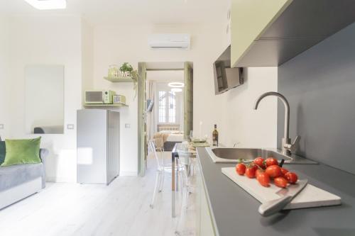 a kitchen with a sink and a counter with tomatoes on it at Cernobbio Dream Suites by Rent All Como in Cernobbio