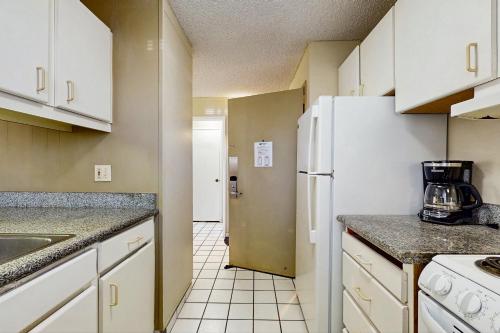 a kitchen with white cabinets and a white refrigerator at Plantation Hale #C5 in Kapaa