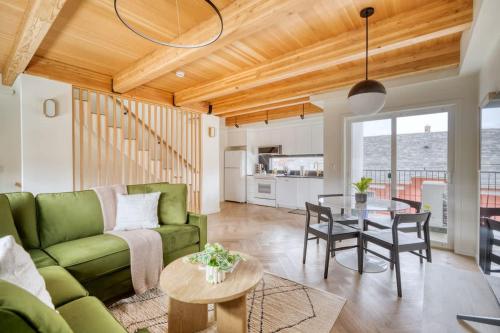 a living room with a green couch and a table at AlbertaArts Happy Place Townhome in Portland